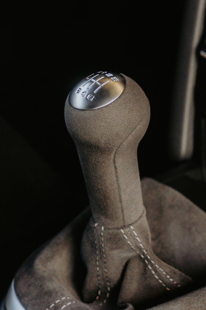 heros-img Close-up of a manual gear shift knob inside a vehicle showcasing automotive craftsmanship.